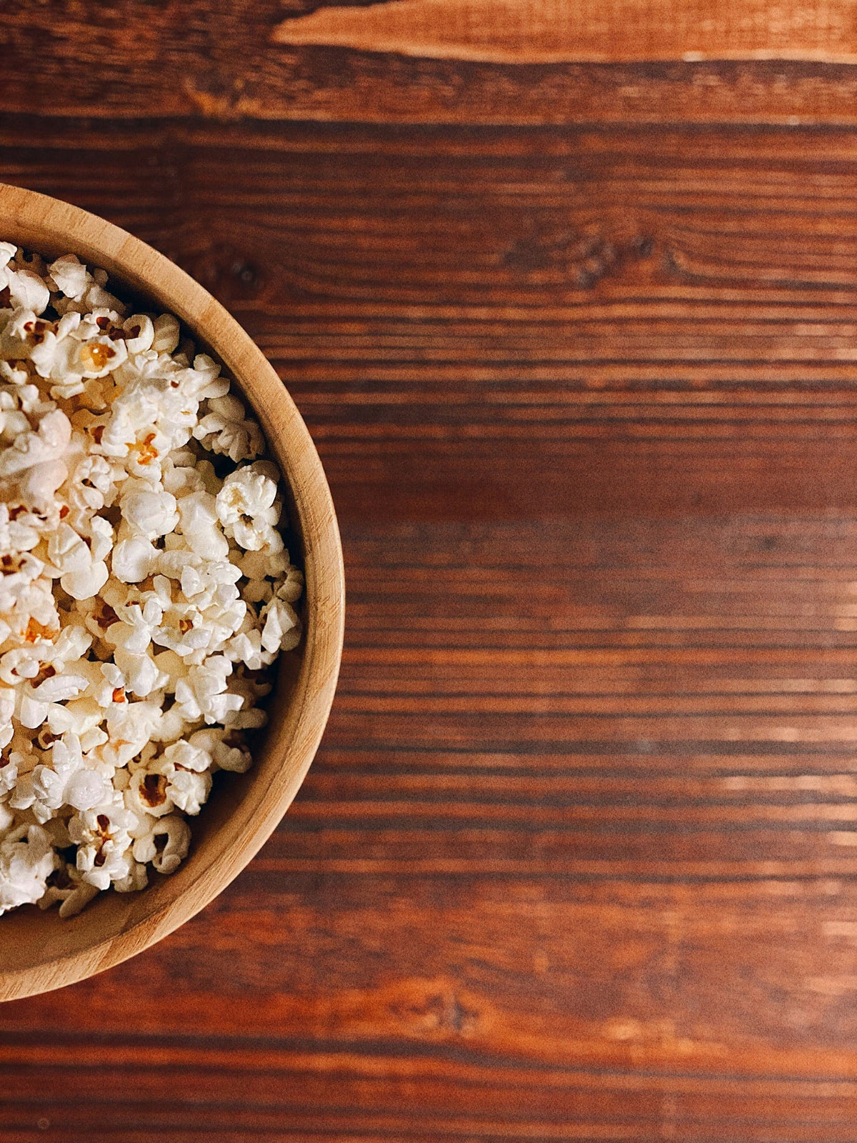 Bowl of fresh air-popped popcorn on a wooden table